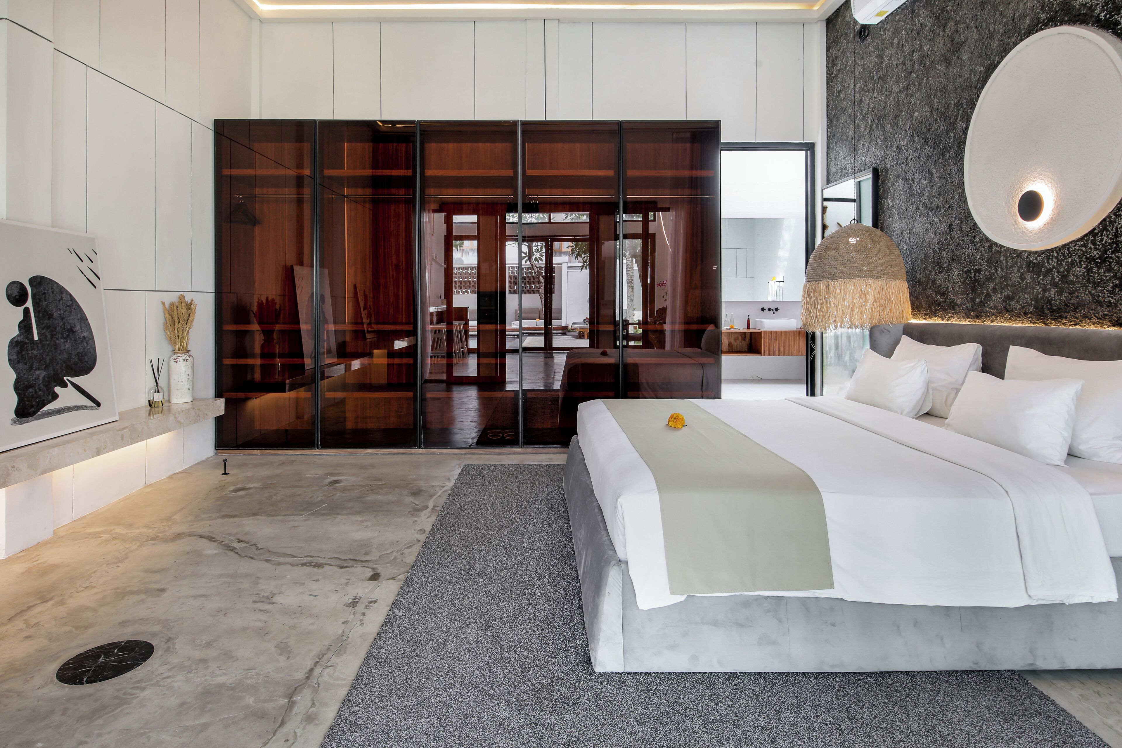 Une chambre moderne avec un grand lit, un miroir et un décor mural original.