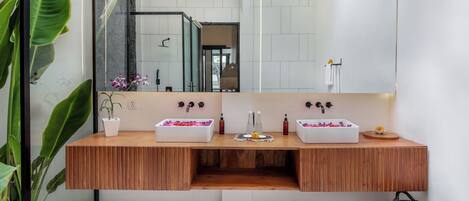 A modern bathroom with a wooden vanity, two sinks, and a large mirror.