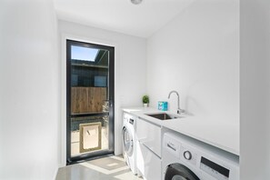 Una cocina compacta con lavadora, lavaplatos y ventana.