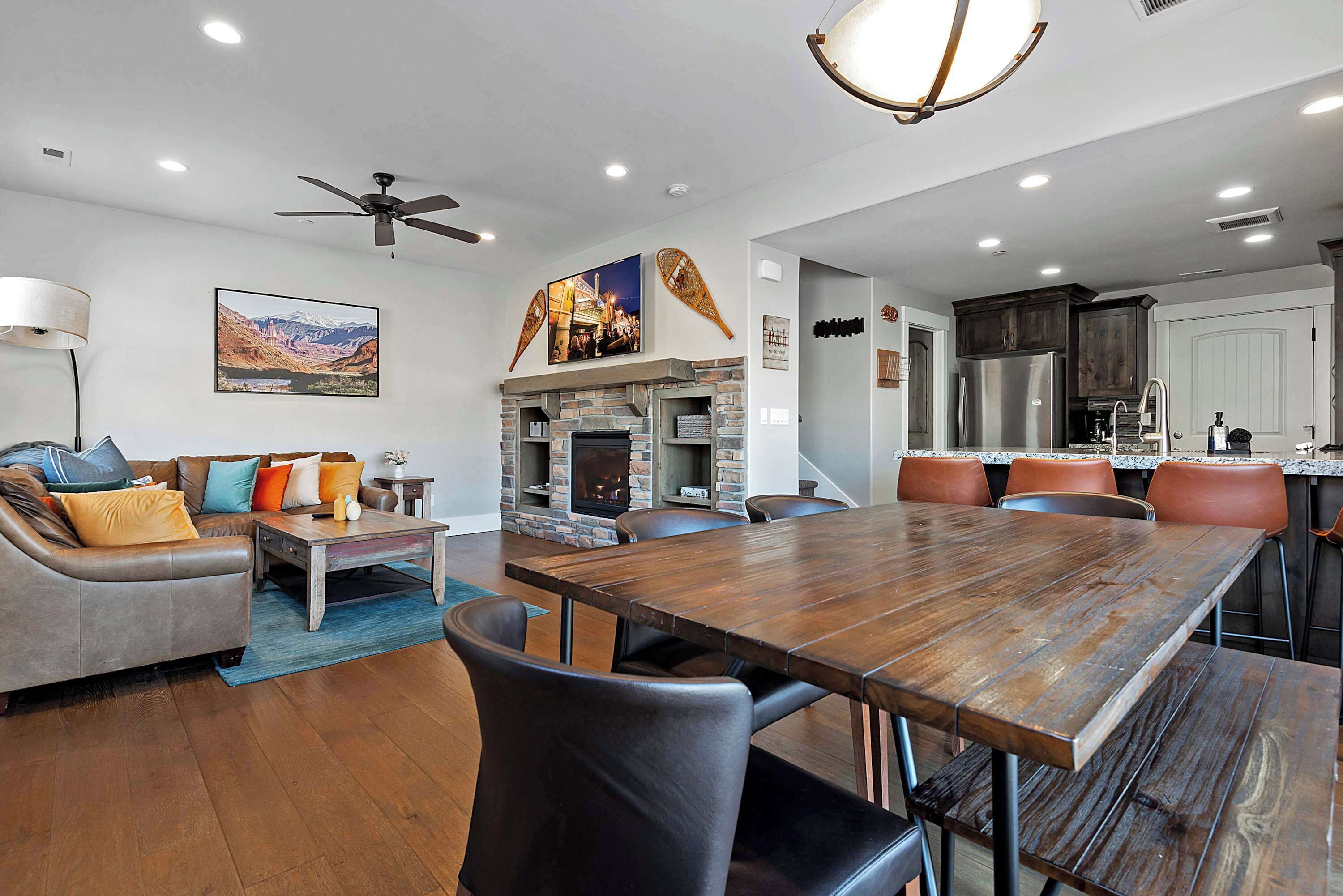 A modern living room with a fireplace, dining table, and comfortable seating.