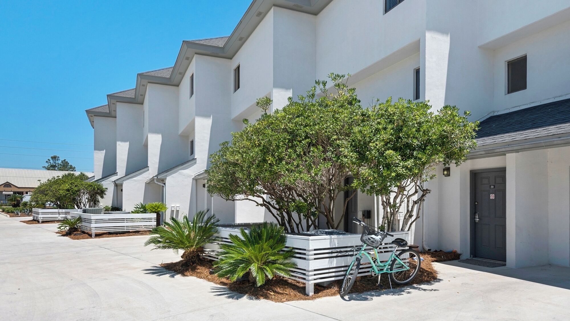 A row of modern white buildings with a bicycle parked in front.