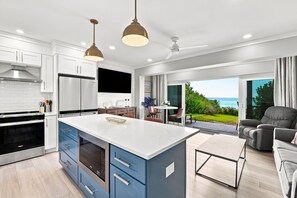 Cocina moderna con una isla central, electrodomésticos integrados y vistas al exterior.