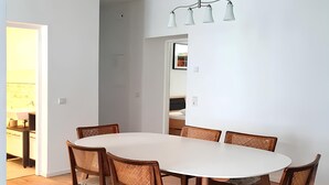 A dining area with a round table, six wooden chairs with woven seats, and a pendant light fixture. - Apartment 'Geräumige Moderne 3 Raumwohnung' with Shared Terrace and Wi-Fi (Dohna)