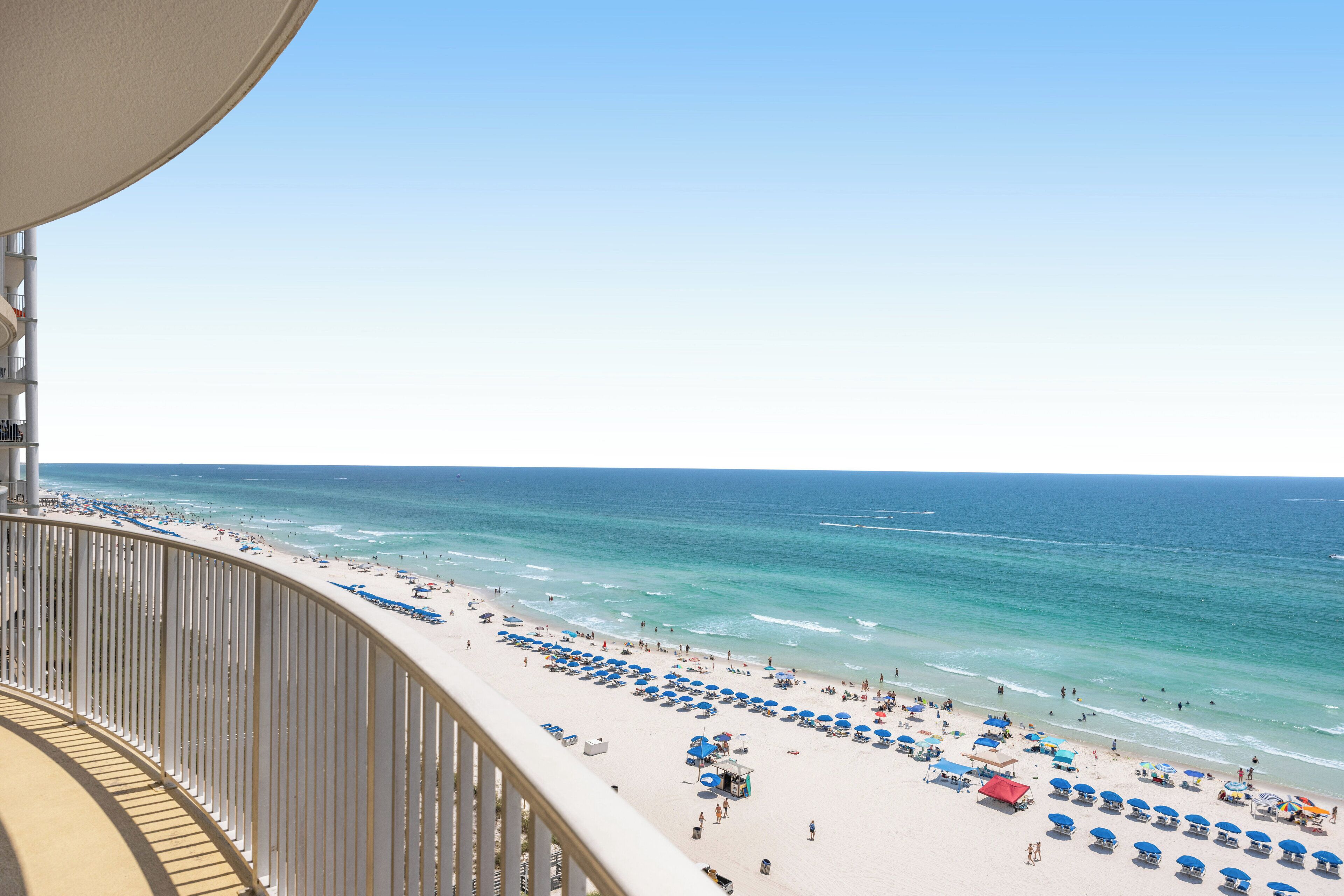 A beach with umbrellas and people.