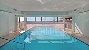 Ein Hallenbad mit freiem Blick auf Strand und Meer.