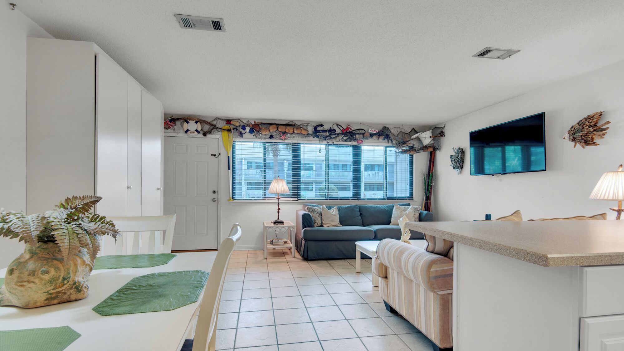 A compact living space with a kitchenette, a dining area, and a seating area with a sofa and chairs.