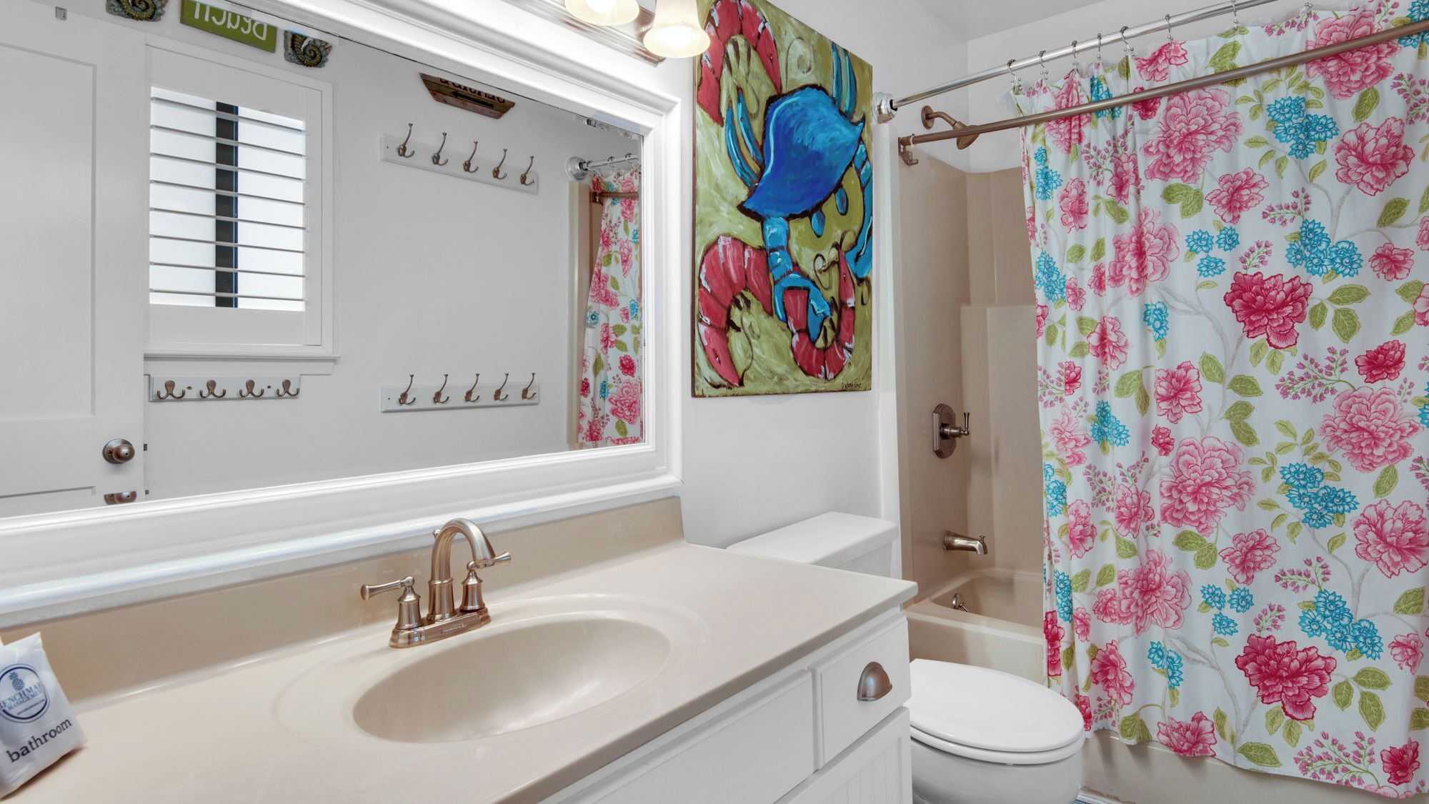 A bathroom with a sink, toilet, and shower curtain.