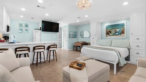 A modern hotel room with a kitchenette, a dining area, a bed, and a living area. - Hidden Beach Villas (Santa Rosa Beach)