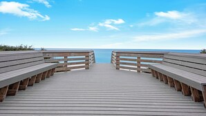 A wooden boardwalk leading to a beach with benches on either side. - Hidden Beach Villas (Santa Rosa Beach)