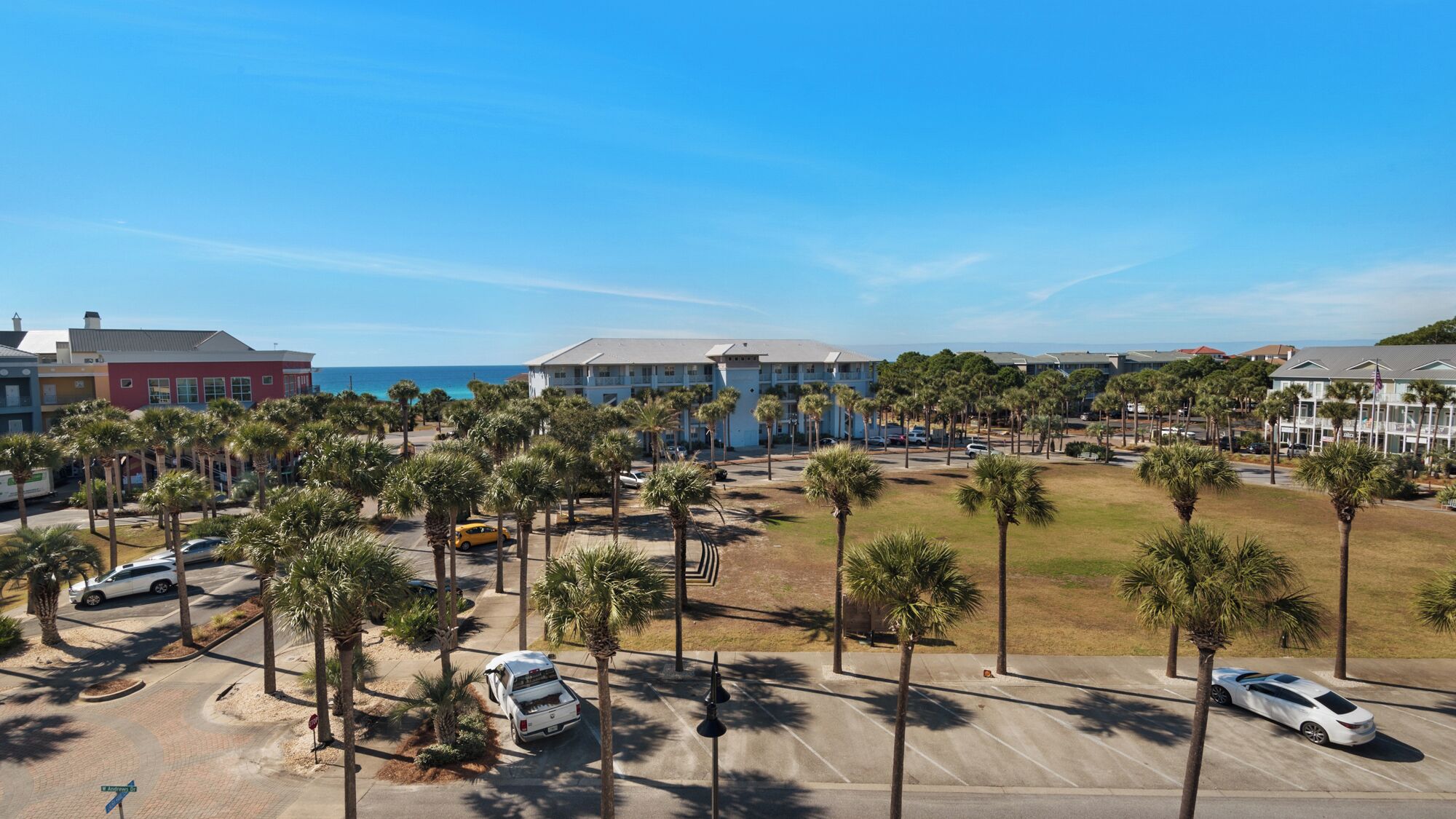 Un hotel con parcheggio, palme e vista sull'oceano.