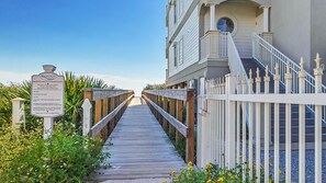 Stroll along the boardwalk to the entrance of this charming beach property, where lush greenery and a classic architectural style await.