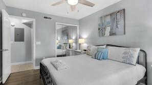 A bedroom with a bed, bedside lamps, a mirror, and a ceiling fan. - Mistral 10- Gulf Front - Seacrest Beach (Panama City Beach)