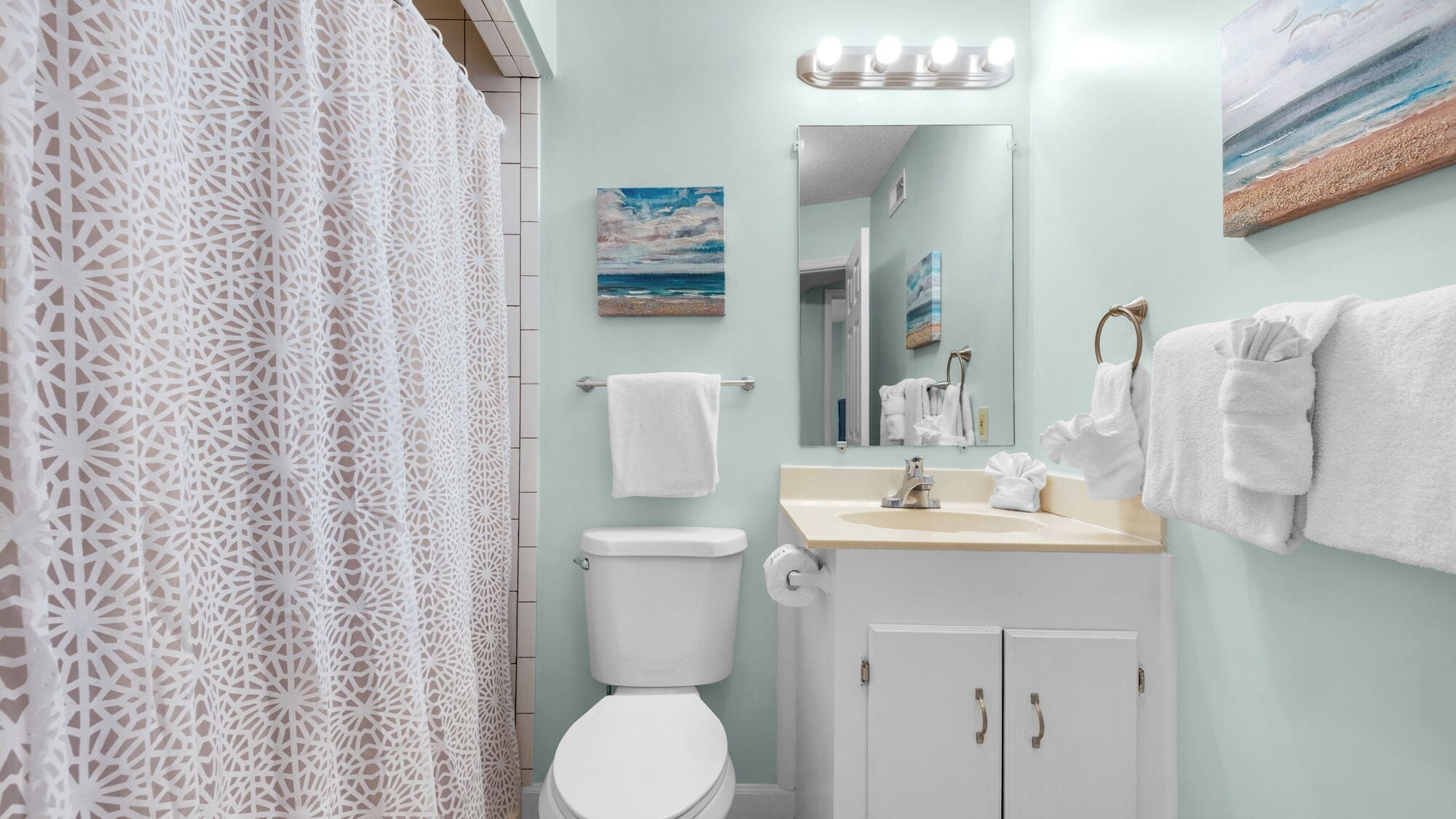 Un bagno con il water, un lavandino e un portasciugamani.