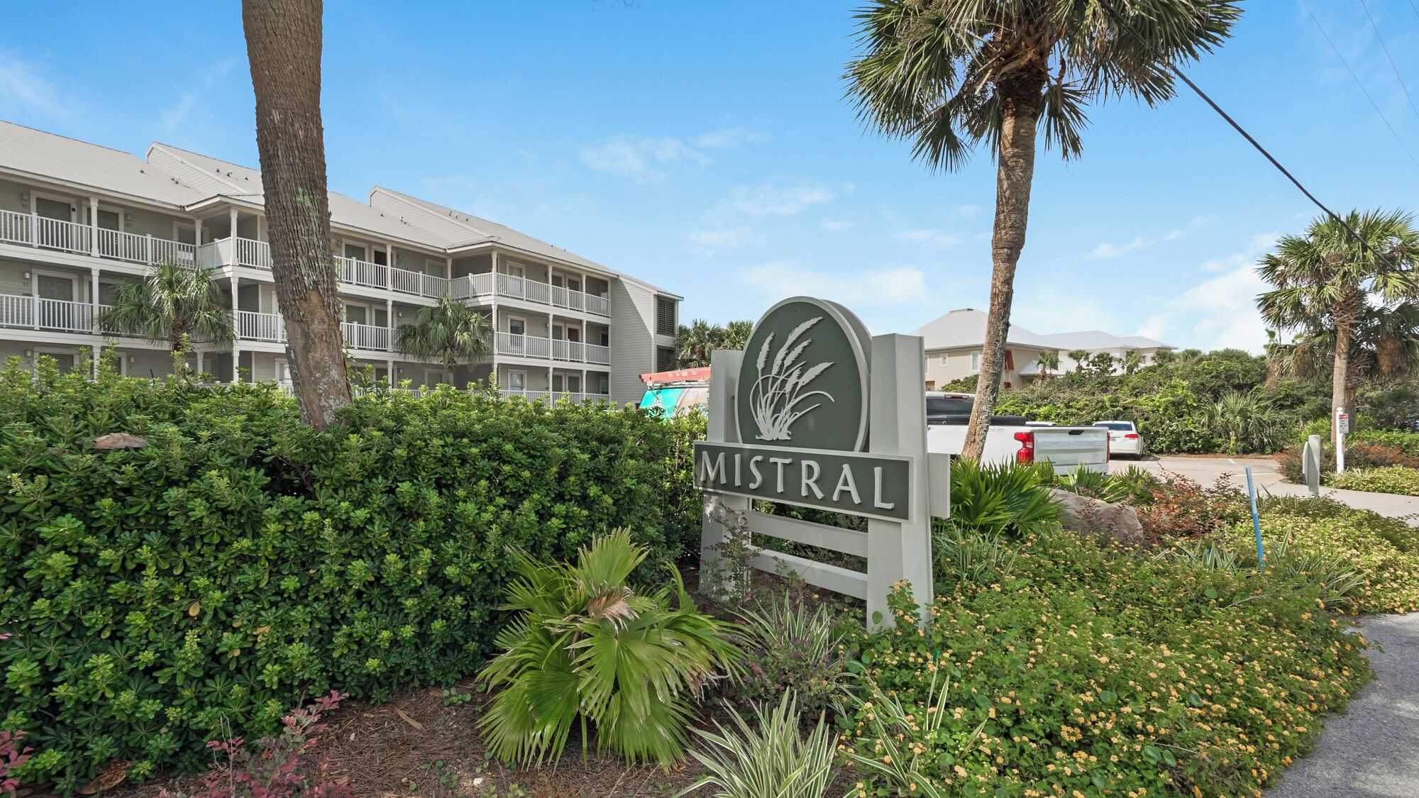 A sign for Mistral with a multi-story building in the background.