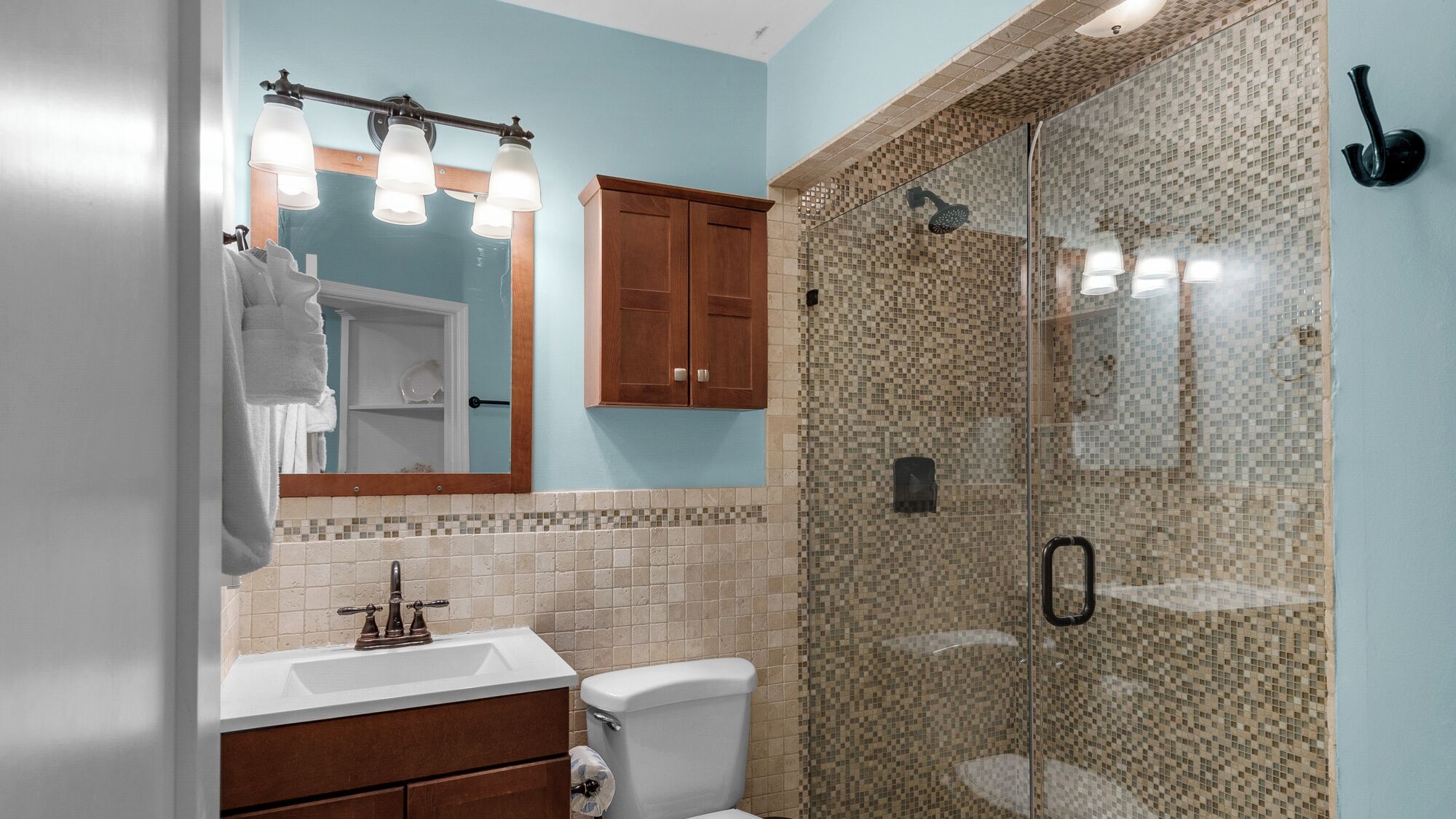 Une salle de bain avec une douche, un lavabo et un miroir.