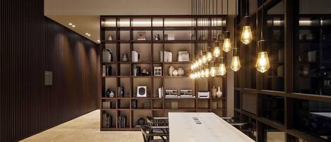 Una sala de conferencias moderna con una larga mesa, sillas y una estantería llena de libros y objetos decorativos.