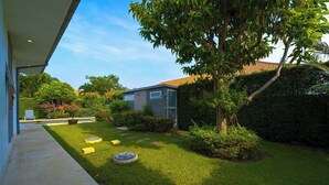 A well-maintained garden with a lawn, a small shed, and a tree. - Modern 3 Bedroom Pool Villa - MR54 (Hua Hin)
