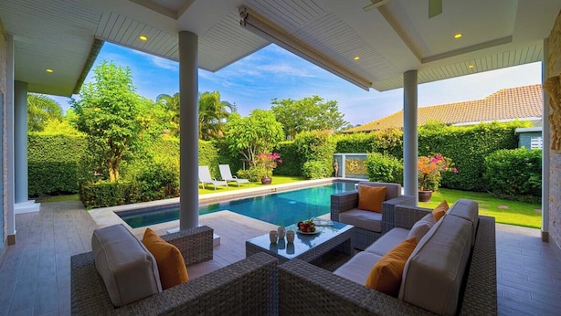 A covered outdoor area with a pool, seating, and lush greenery. - Modern 3 Bedroom Pool Villa - MR54 (Hua Hin)