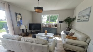 Una sala de estar moderna con un sofá, una mesa de centro y un televisor.