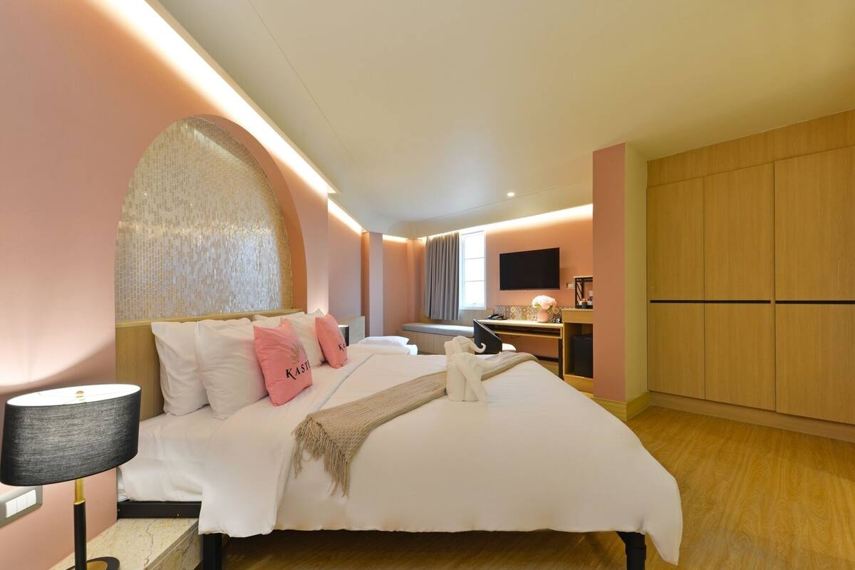 Une chambre à coucher moderne avec un grand lit, un bureau et un téléviseur.