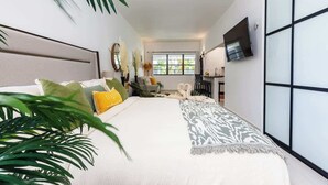 A modern bedroom with a bed, a TV, and a large window. - Beautiful Retreat w. Pool and Perfect Location (San Juan)