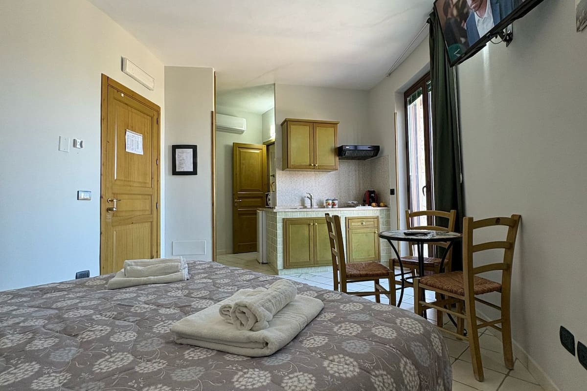 Ein Schlafzimmer mit einem Bett, einem Schreibtisch und einem Fernseher.
