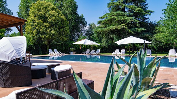 A poolside area with lounge chairs, umbrellas, and a pergola. - Villa Vitti's - Verona est  (San Martino Buon Albergo)