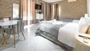 A modern hotel room with a large bed, a desk with a chair, a television, and a minibar. - Villa Vitti's - Verona est  (San Martino Buon Albergo)