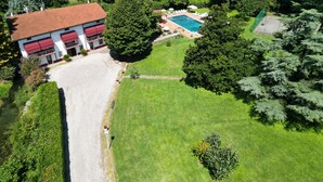 An aerial view of a property with a swimming pool, a large lawn, and a building with a red roof. - Villa Vitti's - Verona est  (San Martino Buon Albergo)