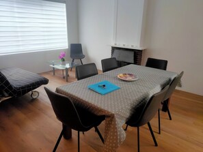 A dining area with a table, chairs, a small table with a glass top, and a chair with wheels. - Huis met Tuin in het Centrum Vlakbij de zee en Amsterdam (Beverwijk)