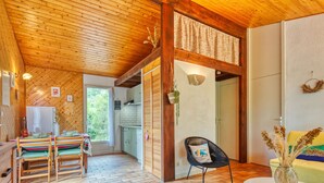 Ein Holzinterieur mit Essbereich, einer Küche und einer Sitzecke mit Tisch und Stühlen.