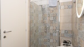 Un bagno con doccia, lavandino e specchio.