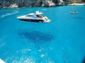 A large yacht on a clear blue sea with rocky cliffs in the background. - Seaview Cottage Walk to Beach Sunset Terrace (Trinità d'Agultu e Vignola)