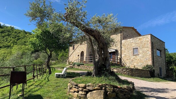 A stone building with a rustic stone wall and a wooden fence. - Apartment on the Hill Between Gubbio and Perugia (Perugia)
