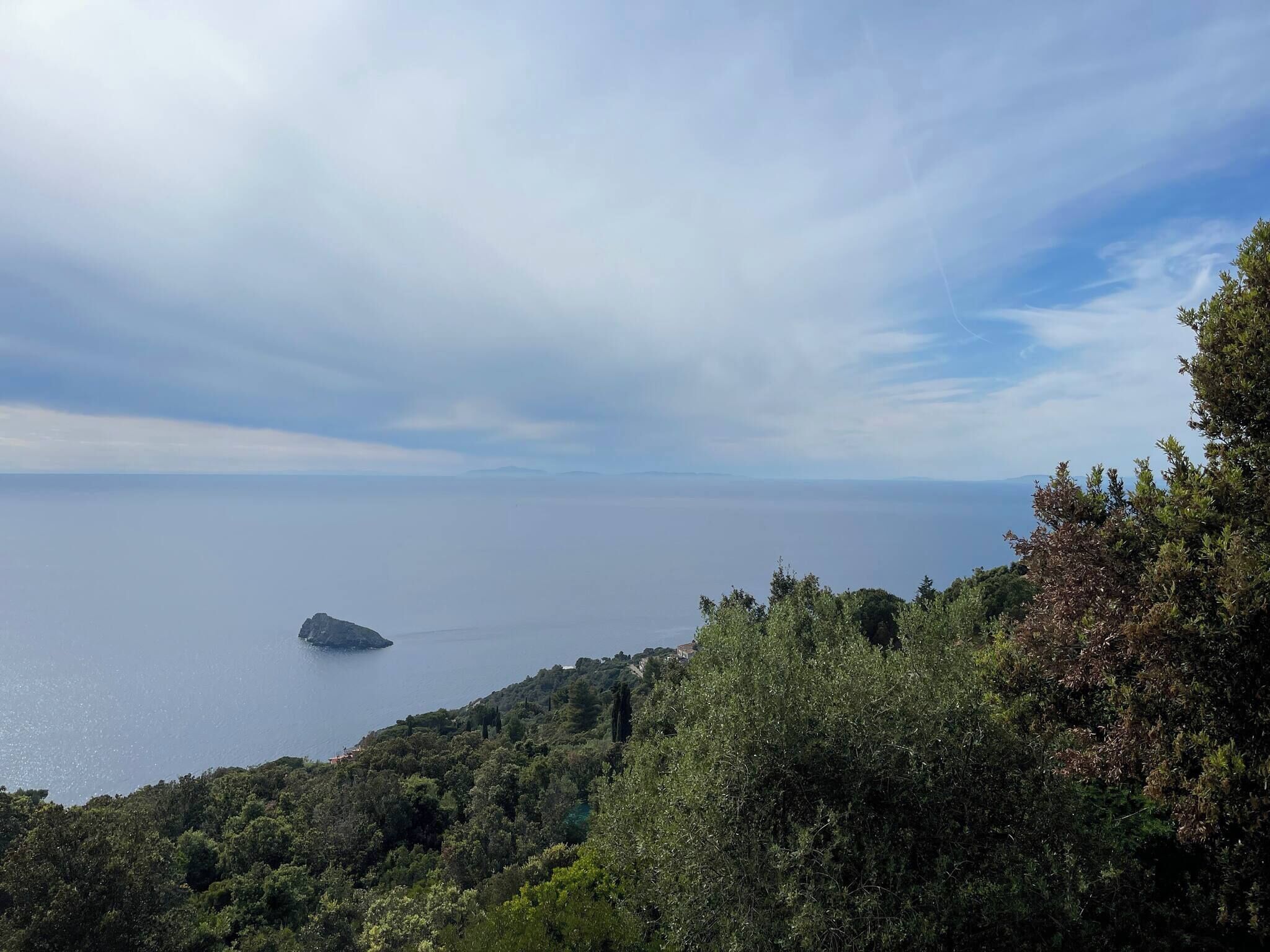 Un paisaje costero con vista al mar y una pequeña isla.