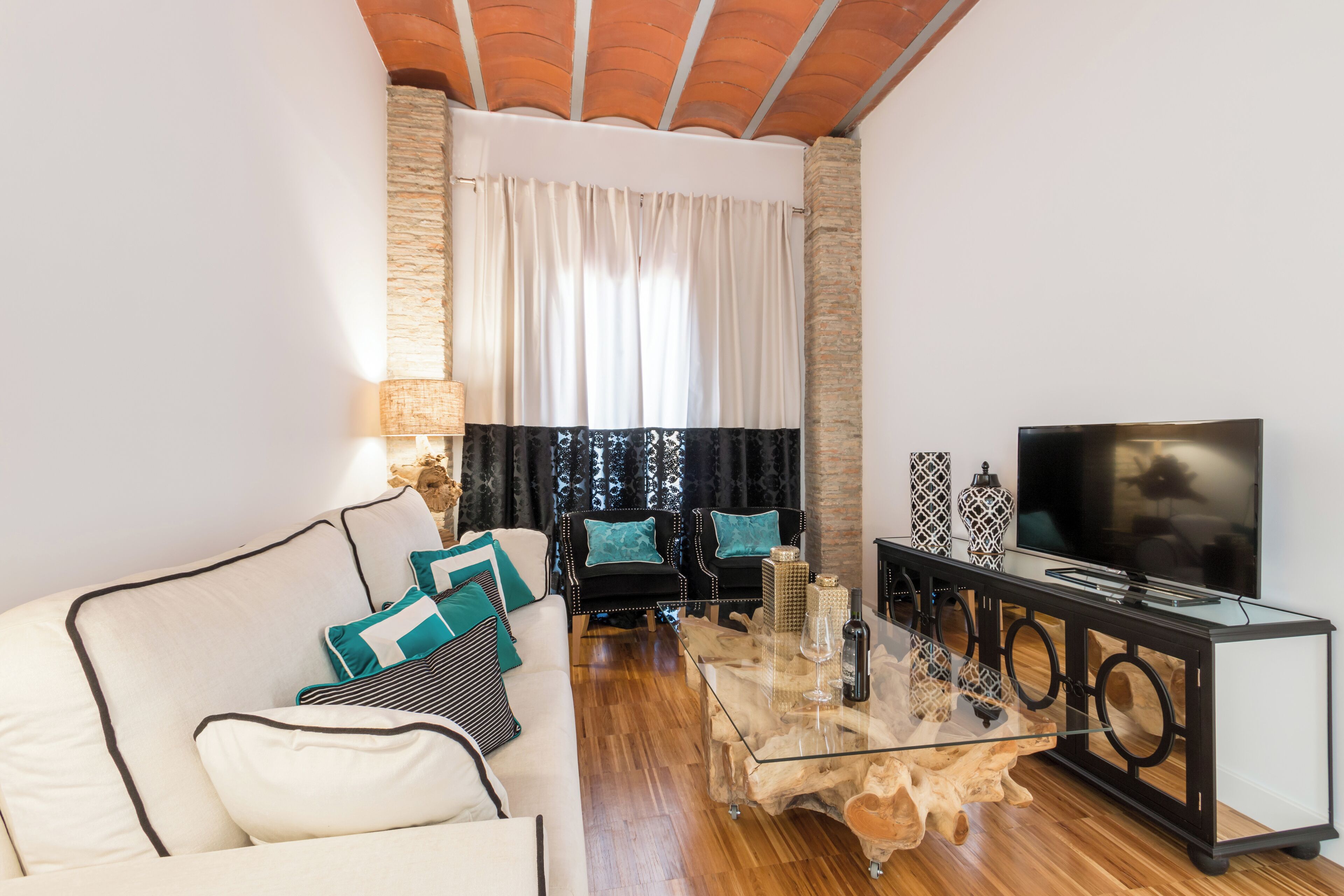 Una sala de estar moderna con un sofá, sillones, una mesa de centro y un televisor.