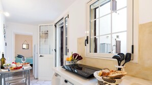 Une cuisine compacte comprenant un coin repas, une cuisinière intégrée et une fenêtre donnant sur un paysage agréable.