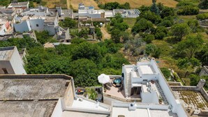 Vue aérienne d’un quartier résidentiel comprenant plusieurs immeubles, une piscine et de nombreux espaces verts.