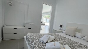 Un dormitorio moderno con cama, mesita de noche y armario.