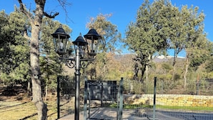 A wooden deck with a metal fence, a lamp post, and a bench.