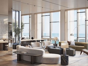 A spacious living area with large windows, a modern sofa set, a coffee table, and a view of the ocean. - Delano Dubai (Dubai)