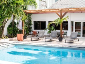A poolside area with lounge chairs, a pergola, and potted plants. - Ibis Styles Cayenne Centre Amazonia (Ouverture Juin 2024) (Cayenne)