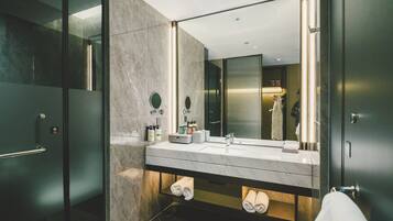 Une salle de bain moderne dotée d’un grand miroir, de deux vasques et d’une douche à parois de verre.