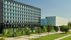 Een modern gebouw met een raster van ramen en een bord waarop 'pullman' staat.