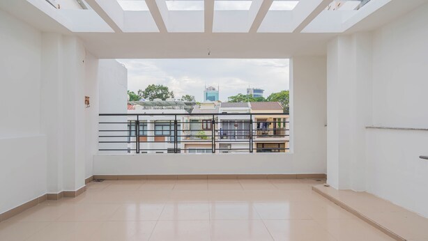 A spacious room with a large window overlooking a balcony and cityscape. - LaLaHouse Riverside Residence (Ho Chi Minh City)