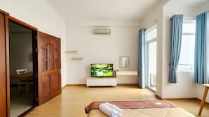 A bedroom with a bed, a TV, a desk, and a wardrobe. - LaLaHouse Riverside Residence (Ho Chi Minh City)