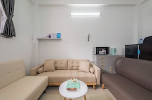 Habitación doble superior, vista a la ciudad | Área de sala de estar | Televisión de pantalla plana de 16 pulgadas con canales por cable 