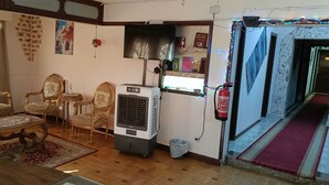 A living room with a sofa, two armchairs, a coffee table, and a wall-mounted air conditioner. - LUNA HOTEL (Cairo)
