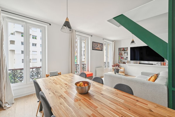 Relax in this inviting living space with a dining table, comfortable seating, and a large window offering a view.