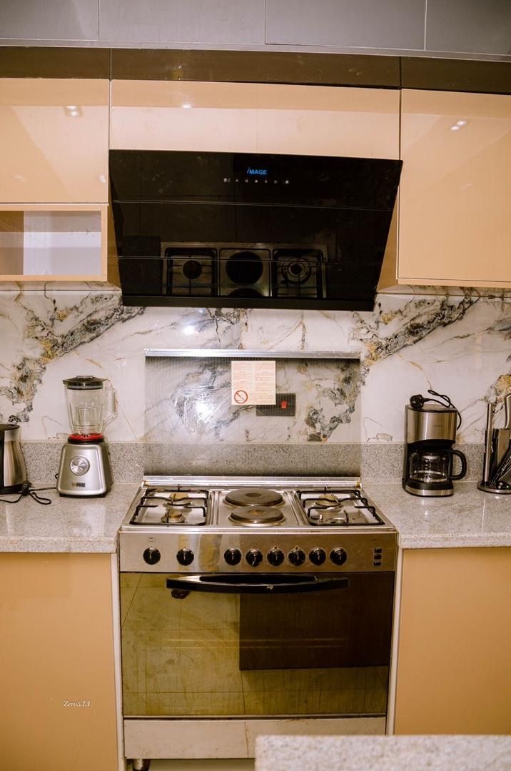 A kitchen with a stove, oven, and a coffee maker on the counter.
